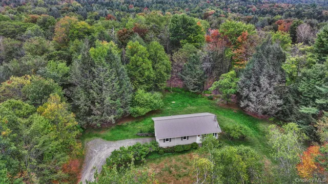 an aerial view of a house with a yard and trees