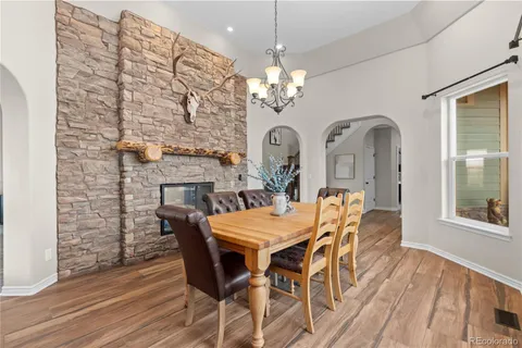 a view of a dining room with furniture a chandelier and wooden floor