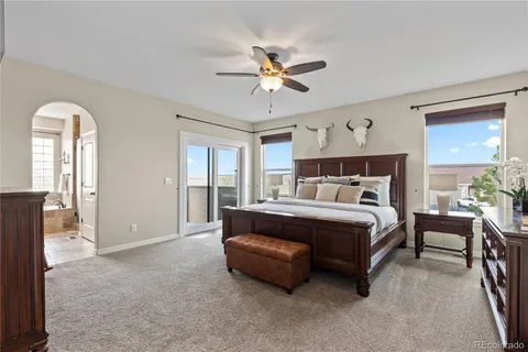 a bed sitting in a bedroom next to a window and a chandelier