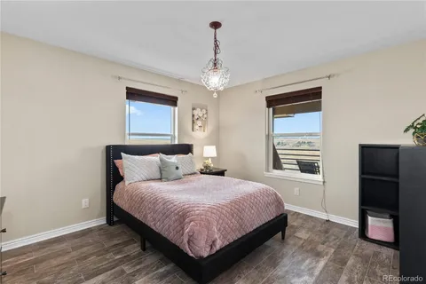 a bedroom with a large bed chandelier and a window
