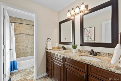a bathroom with a granite countertop sink double vanity and a mirror