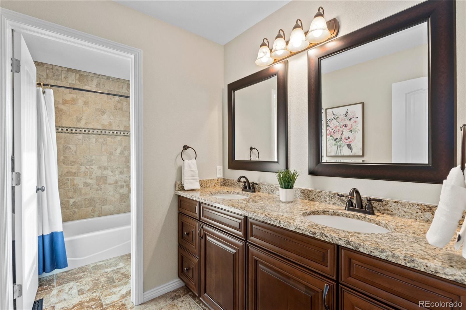41900 East Muirfield Loop Elizabeth, CO 80107 - Photo 20 of 26 a bathroom with a granite countertop sink double vanity and a mirror