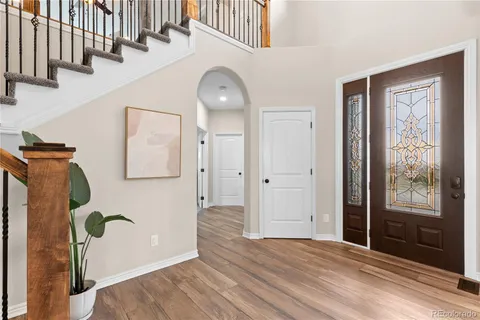 a view of a hallway with entryway wooden floor and front door