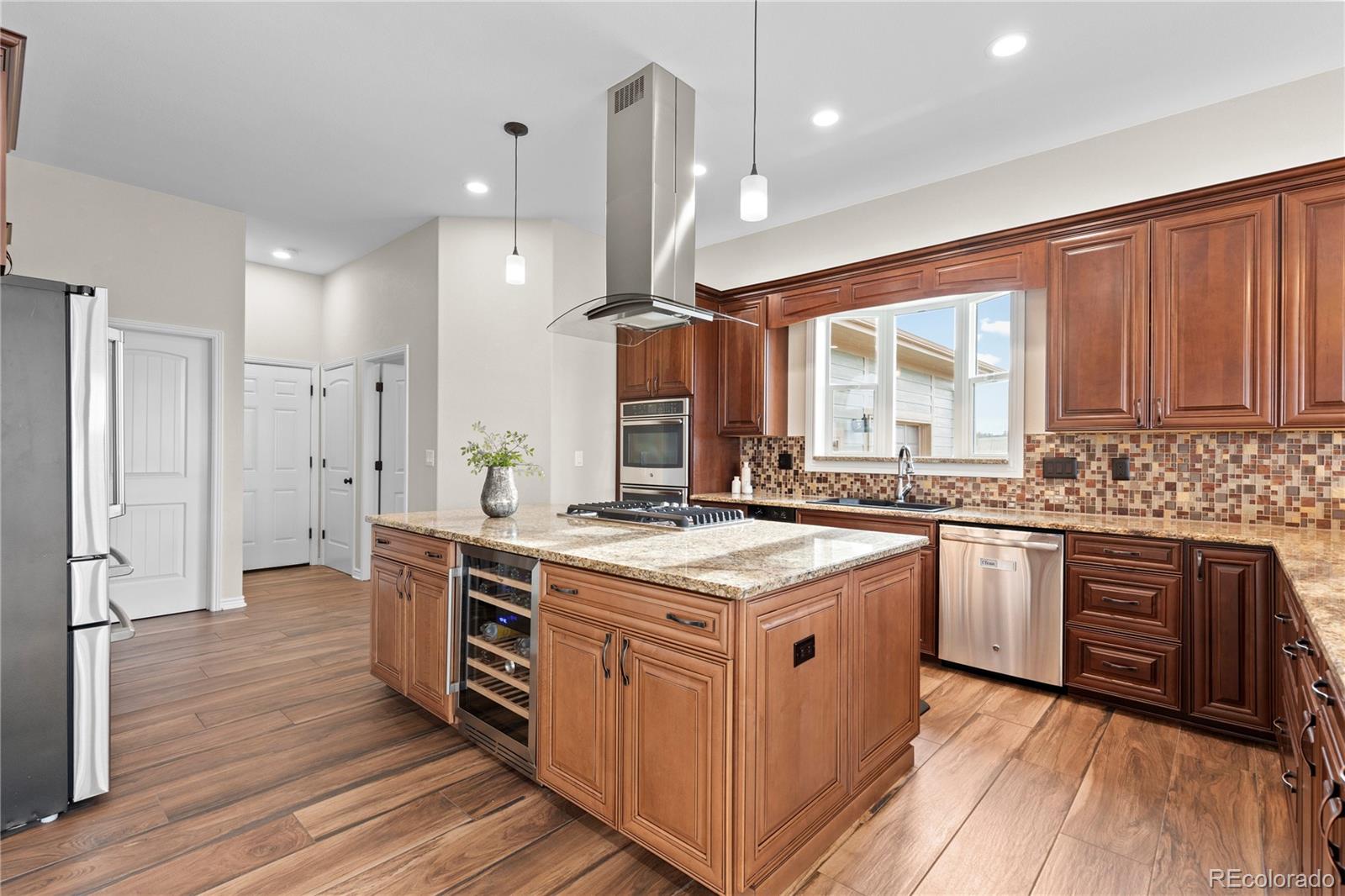 41900 East Muirfield Loop Elizabeth, CO 80107 - Photo 7 of 26 a kitchen with stainless steel appliances granite countertop wooden floors and sink
