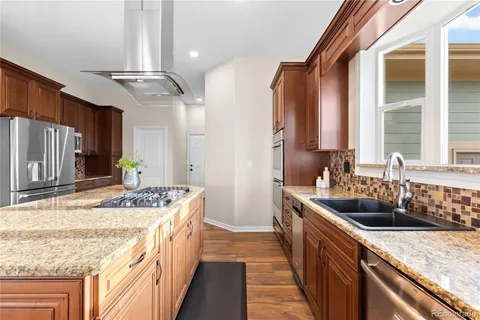a kitchen with stainless steel appliances granite countertop a sink stove and refrigerator