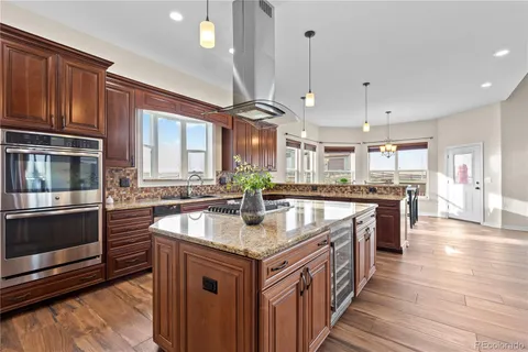 a kitchen with stainless steel appliances granite countertop a kitchen island a stove and a sink