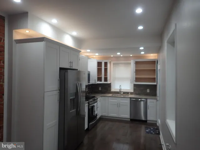 a kitchen with stainless steel appliances a refrigerator a sink a stove a microwave and island