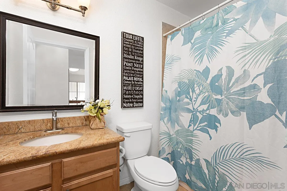 615 Fredricks Avenue, Unit 159 Oceanside, CA 92058 - Photo 22 of 26 a bathroom with a granite countertop sink and a mirror