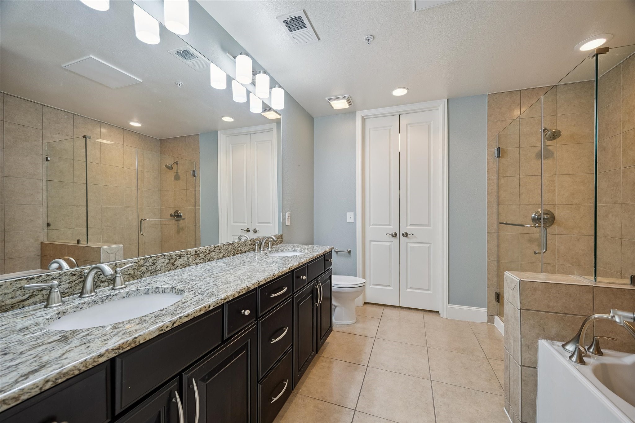 2120 Kipling Street, Unit 304 Houston, TX 77098 - Photo 16 of 24 The ensuite primary bath includes dual sinks, a soaking tub, and a walk-in shower designed for a relaxing everyday routine. Thoughtful storage and a spacious layout make the space both functional and comfortable.