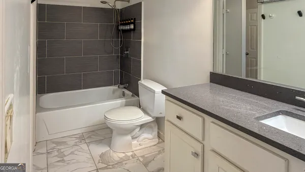 a bathroom with a granite countertop toilet a sink and bathtub