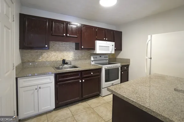 a kitchen with stainless steel appliances granite countertop a sink stove and microwave