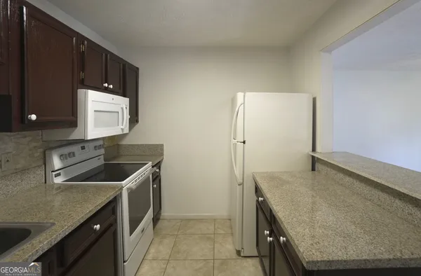 a kitchen with granite countertop a sink and a stove top oven
