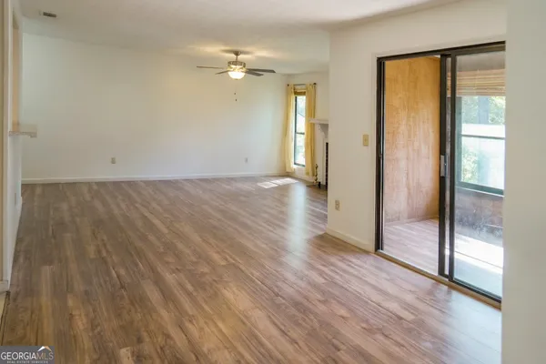an empty room with wooden floor and mirror