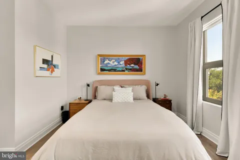 a bedroom with a bed and a painting on the wall