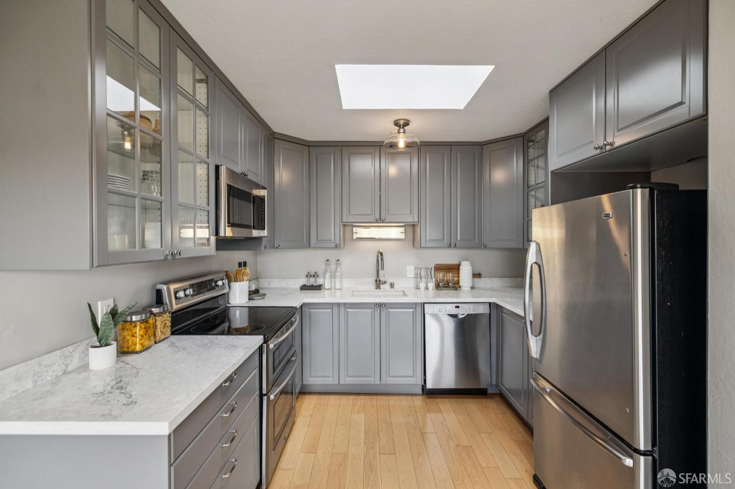 935 Filbert Street, Unit 3 San Francisco, CA 94133 - Photo 27 of 44 a kitchen with a sink dishwasher a refrigerator a stove and white cabinets with wooden floor