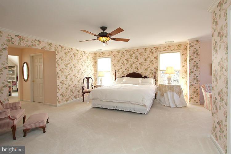 1296 Gatesmeadow Way Reston, VA 20194 - Photo 17 of 29 a bedroom with a large bed and a chandelier