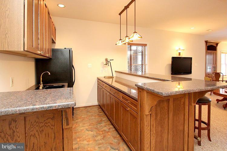 1296 Gatesmeadow Way Reston, VA 20194 - Photo 24 of 29 a kitchen with stainless steel appliances granite countertop a sink a stove and a wooden cabinets
