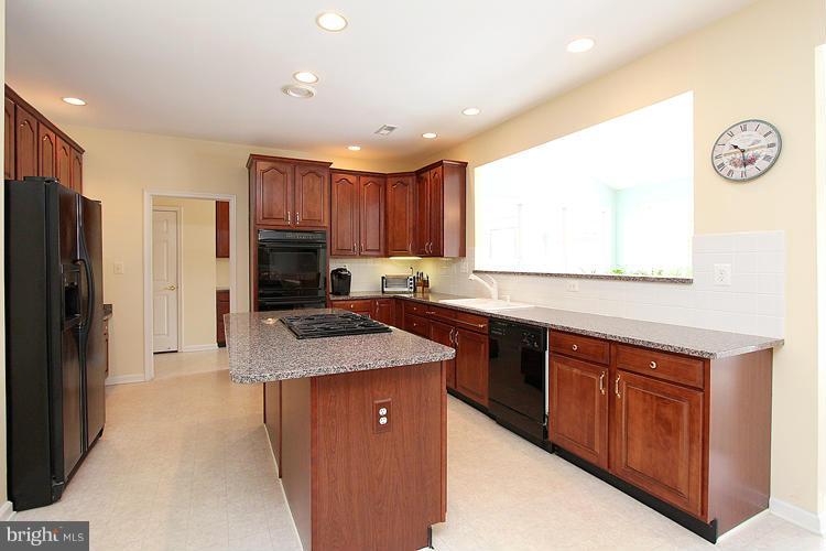 1296 Gatesmeadow Way Reston, VA 20194 - Photo 9 of 29 a kitchen with stainless steel appliances granite countertop wooden cabinets a sink and a stove