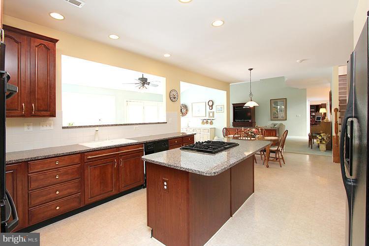 1296 Gatesmeadow Way Reston, VA 20194 - Photo 10 of 29 a kitchen with stainless steel appliances granite countertop a sink a stove a refrigerator and island