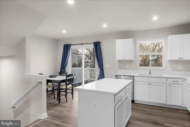 a kitchen with a sink dining table and chairs
