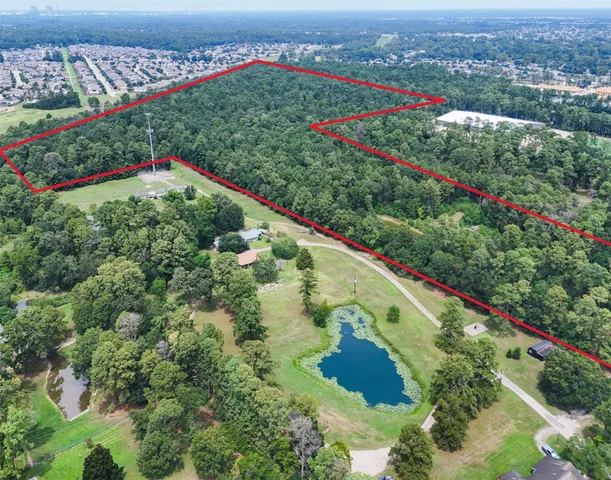 an aerial view of a houses with a yard and lake