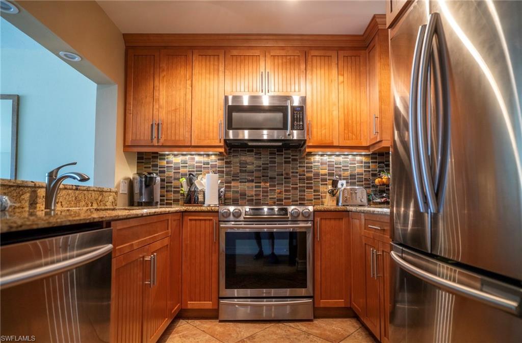 805 River Point Drive, Unit 103C Naples, FL 34102 - Photo 16 of 27 a kitchen with granite countertop a refrigerator stove and sink