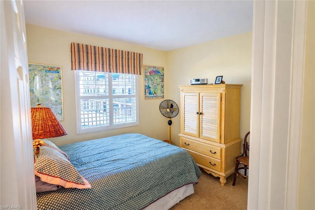 805 River Point Drive, Unit 103C Naples, FL 34102 - Photo 25 of 27 a bedroom with a bed and a window