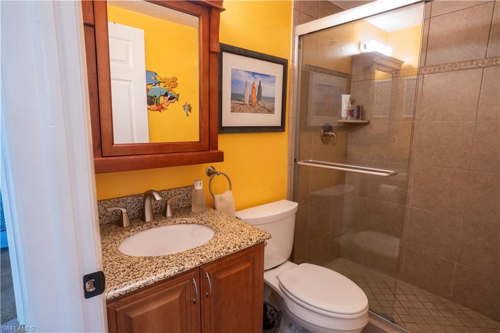 805 River Point Drive, Unit 103C Naples, FL 34102 - Photo 27 of 27 a bathroom with a granite countertop sink toilet a mirror and shower