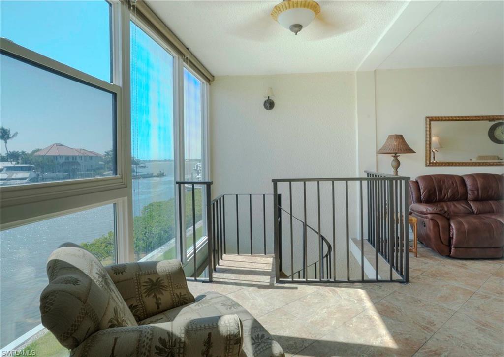805 River Point Drive, Unit 103C Naples, FL 34102 - Photo 10 of 27 a living room with furniture and a floor to ceiling window