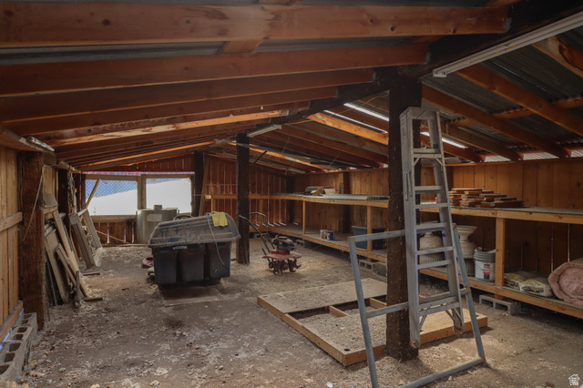 270 East 100 North Monroe, UT 84754 - Photo 54 of 65 Spacious utility structure featuring exposed wood beams, a corrugated metal roof, built-in shelving, and multiple windows providing natural light