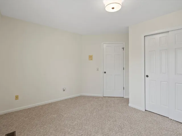 a view of empty room with wooden floor and entryway