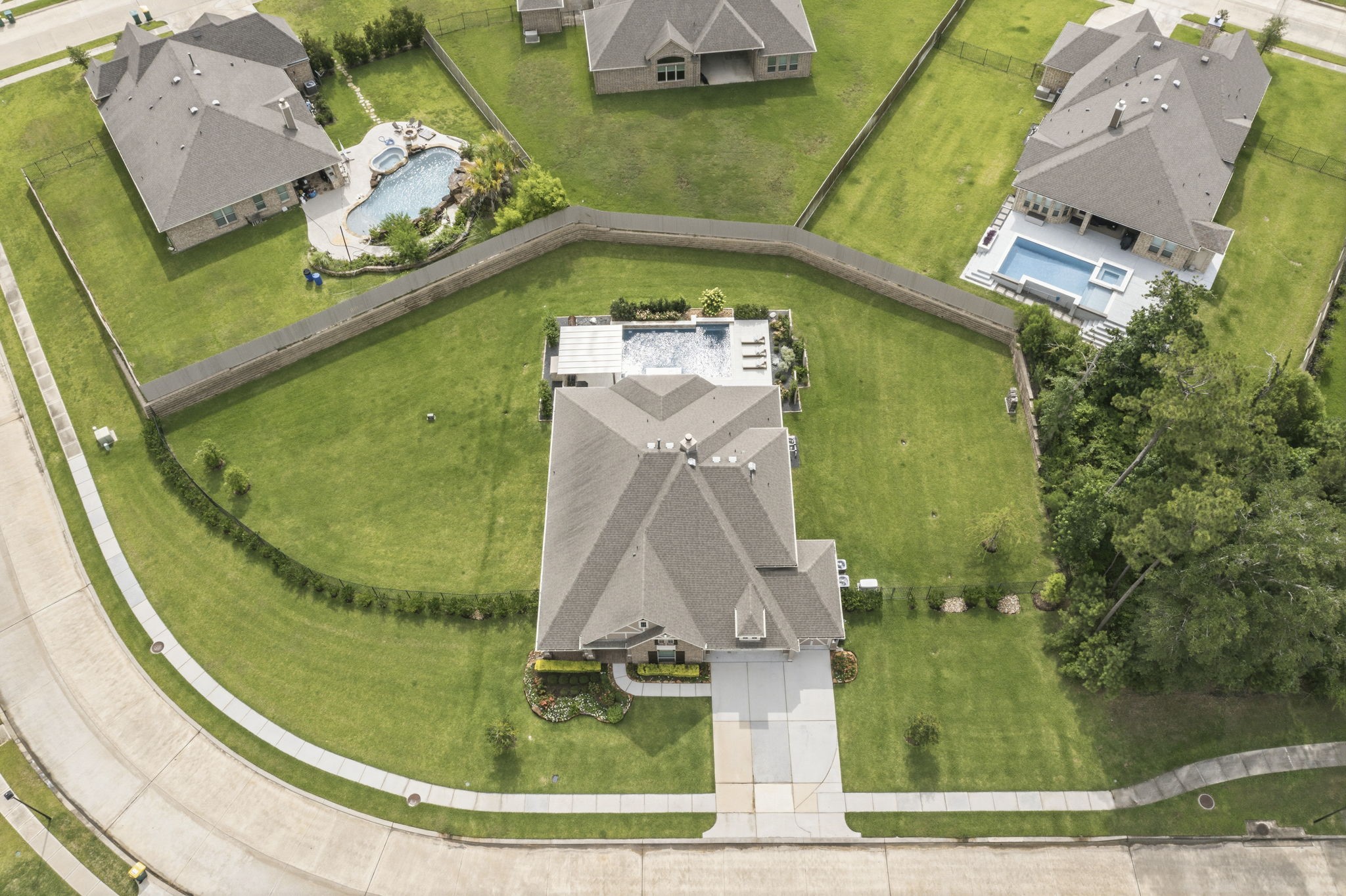 14012 Beartooth Bend Trail Conroe, TX 77384 - Photo 47 of 50 The expansive backyard has been thoughtfully enhanced with a variety of premium upgrades. Front and rear gutters (2020) and an extensive French drain system provide effective rainwater management, while a whole-house generator installed in 2024 offers added comfort and peace of mind during unexpected outages. The backyard landscaping and hardscaping were completely refreshed in 2023, creating a beautiful and functional outdoor environment that complements the home's resort-style amenities.