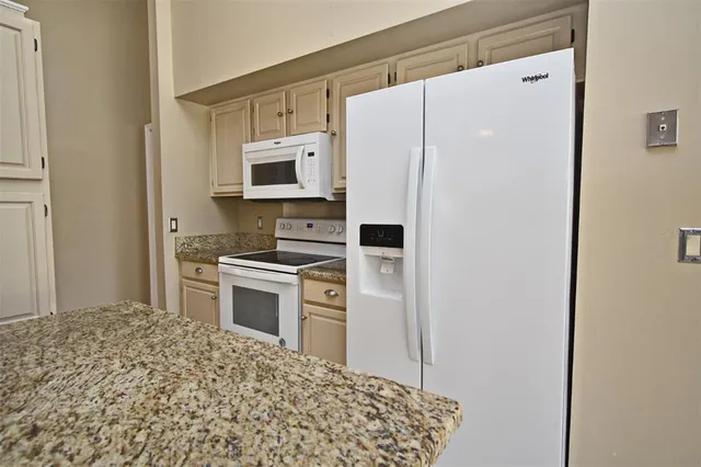 an empty room with wooden floor chandelier fan and windows