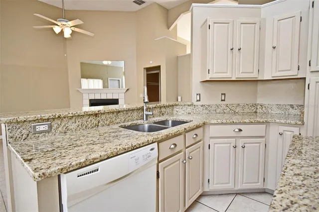 an empty room with wooden floor chandelier fan and windows