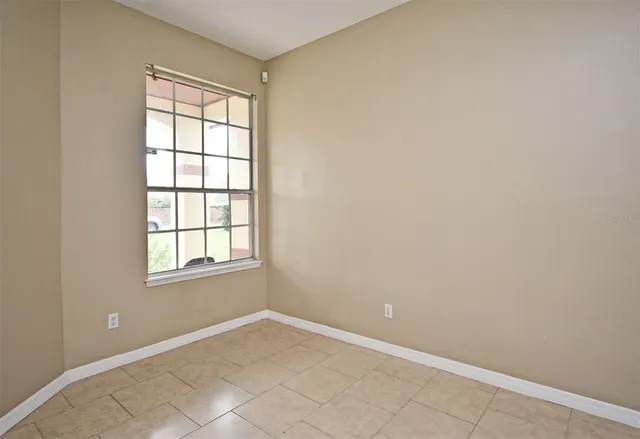 a view of an empty room with a fireplace and a window