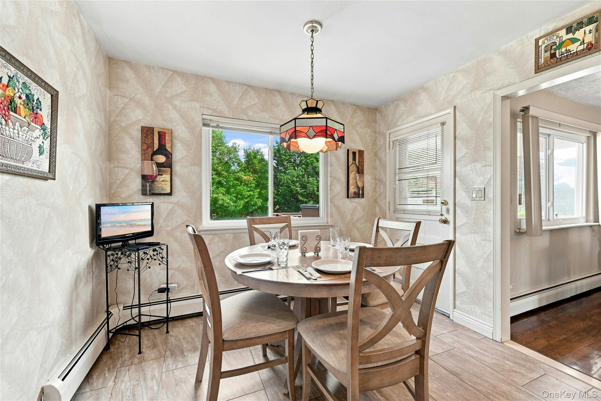 3165 Clubhouse Road Merrick, NY 11566 - Photo 23 of 45 Bright dining area featuring a round table, wood-finish flooring, and large windows with natural light