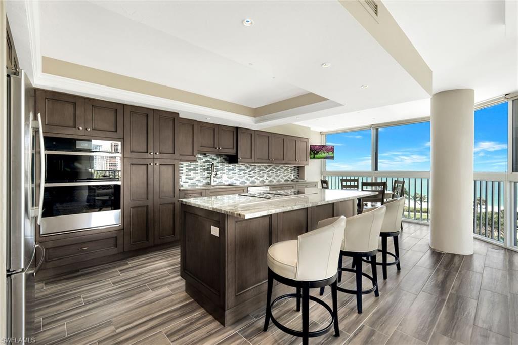 a kitchen with kitchen island granite countertop wooden floor and stainless steel appliances