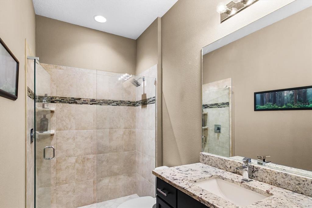 7612 Alumni Trail Sarasota, FL 34243 - Photo 13 of 35 a bathroom with a granite countertop sink a shower and a mirror