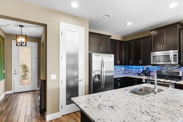 a kitchen with stainless steel appliances kitchen island granite countertop a sink stove and refrigerator