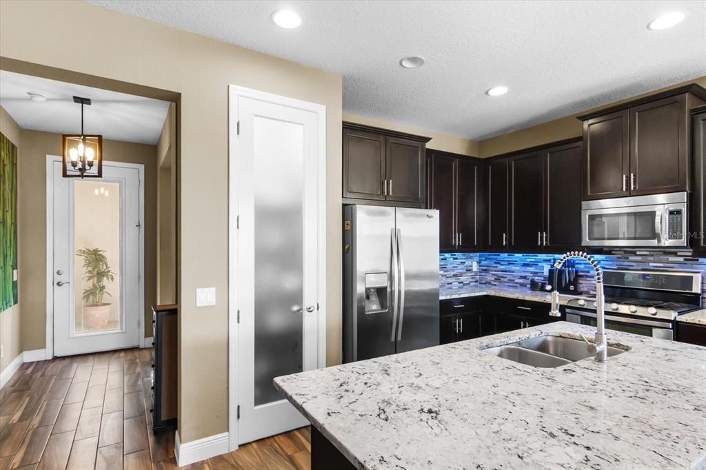 7612 Alumni Trail Sarasota, FL 34243 - Photo 28 of 35 a kitchen with stainless steel appliances wooden floor and a refrigerator