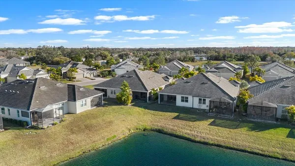 an aerial view of residential houses with yard and ocean view