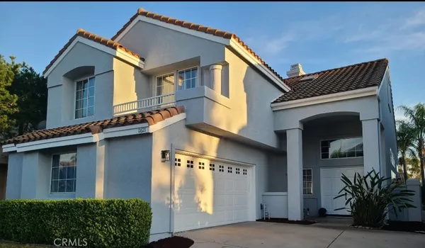 a view of a house with a large windows and plants