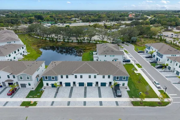 an aerial view of a city with lots of residential buildings ocean and mountain view in back