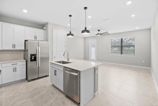 a view of a kitchen sink and refrigerator