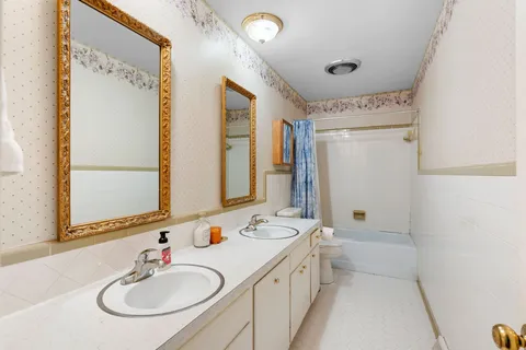 a bathroom with 2 sink tub and a mirror