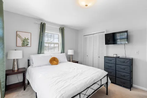 a bedroom with a large bed and a flat screen tv