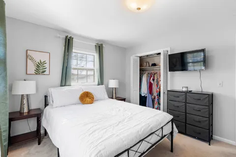 a bedroom with a bed and a flat screen tv