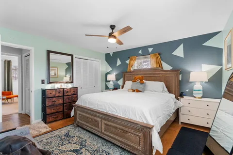 a bedroom with a bed and wooden floor