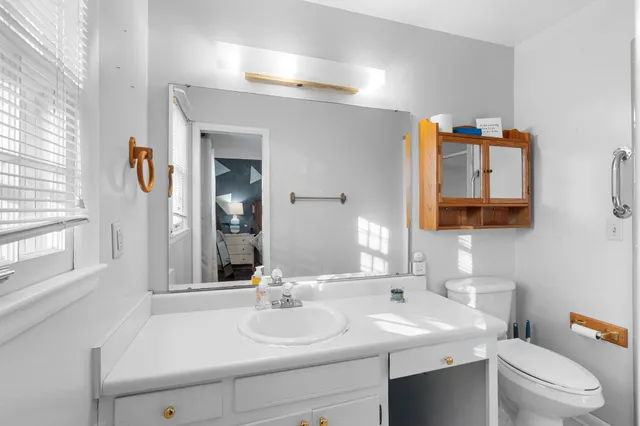 a bathroom with a sink vanity mirror and toilet