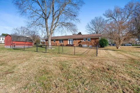 a view of a house with backyard and tree